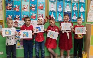 Uczniowie klasy 2a z pracami z Ogólnopolskiego Programu Kodowanie na dywanie.